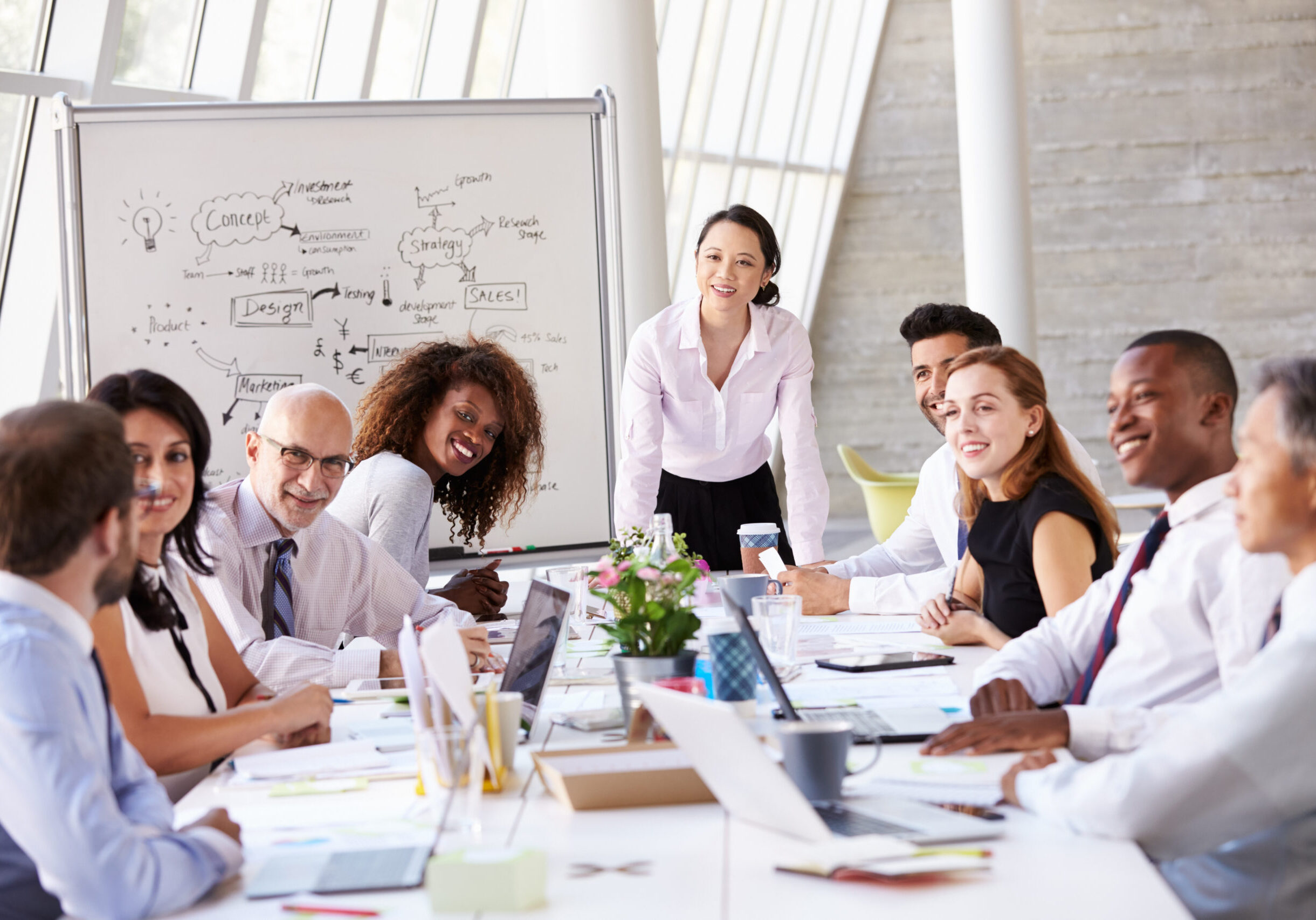 Asian Businesswoman Leading Meeting At Boardroom Table